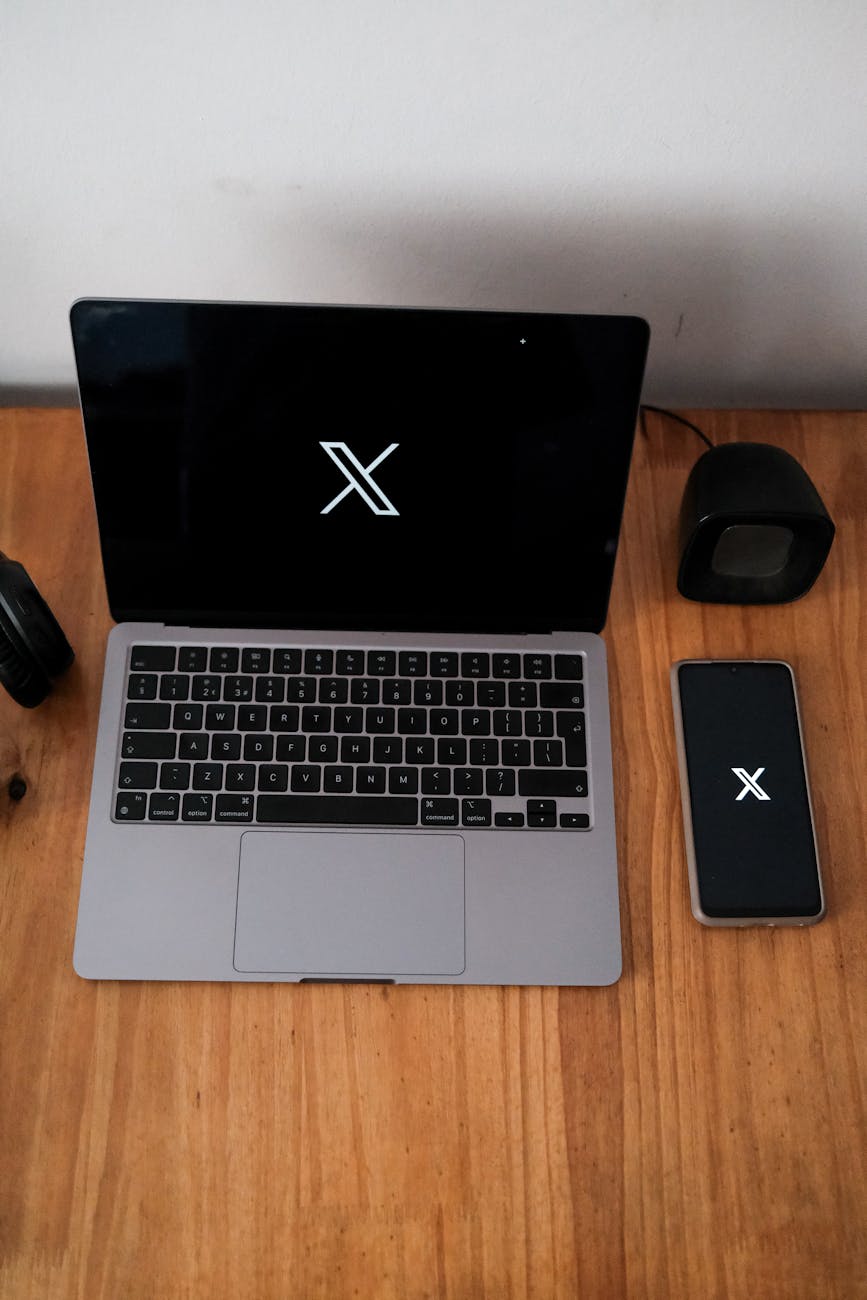 x logo on apple macbook and smartphone on desk